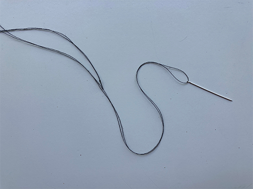 Double thread sewing needle for a ladder stitch to close a hand pillow opening 