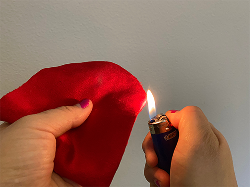 Using a lighter, lightly melt the edges of the velvet nails to make them cleaner looking